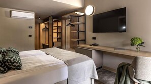 A hotel room with a bed, a desk, a TV, and a wardrobe with a mirror. - Hotel Terme Jezercica (Donja Stubica)