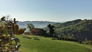 A rural landscape with a house on a hill, surrounded by greenery and a clear sky. - Vuglec Breg (Krapina)