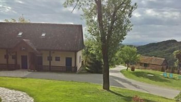 A building with a sloped roof, a paved driveway, and a stone pathway. - Vuglec Breg (Krapina)