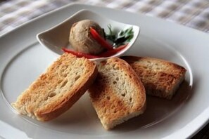 A plate with two slices of toasted bread and a small bowl of a food item. - Vuglec Breg (Krapina)