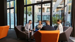 Et moderne mødelokale med store vinduer, behagelige siddepladser og udsigt over bybilledet.