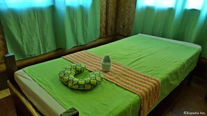 Un lit avec une couvre-lit verte, un oreiller vert et un oreiller blanc.