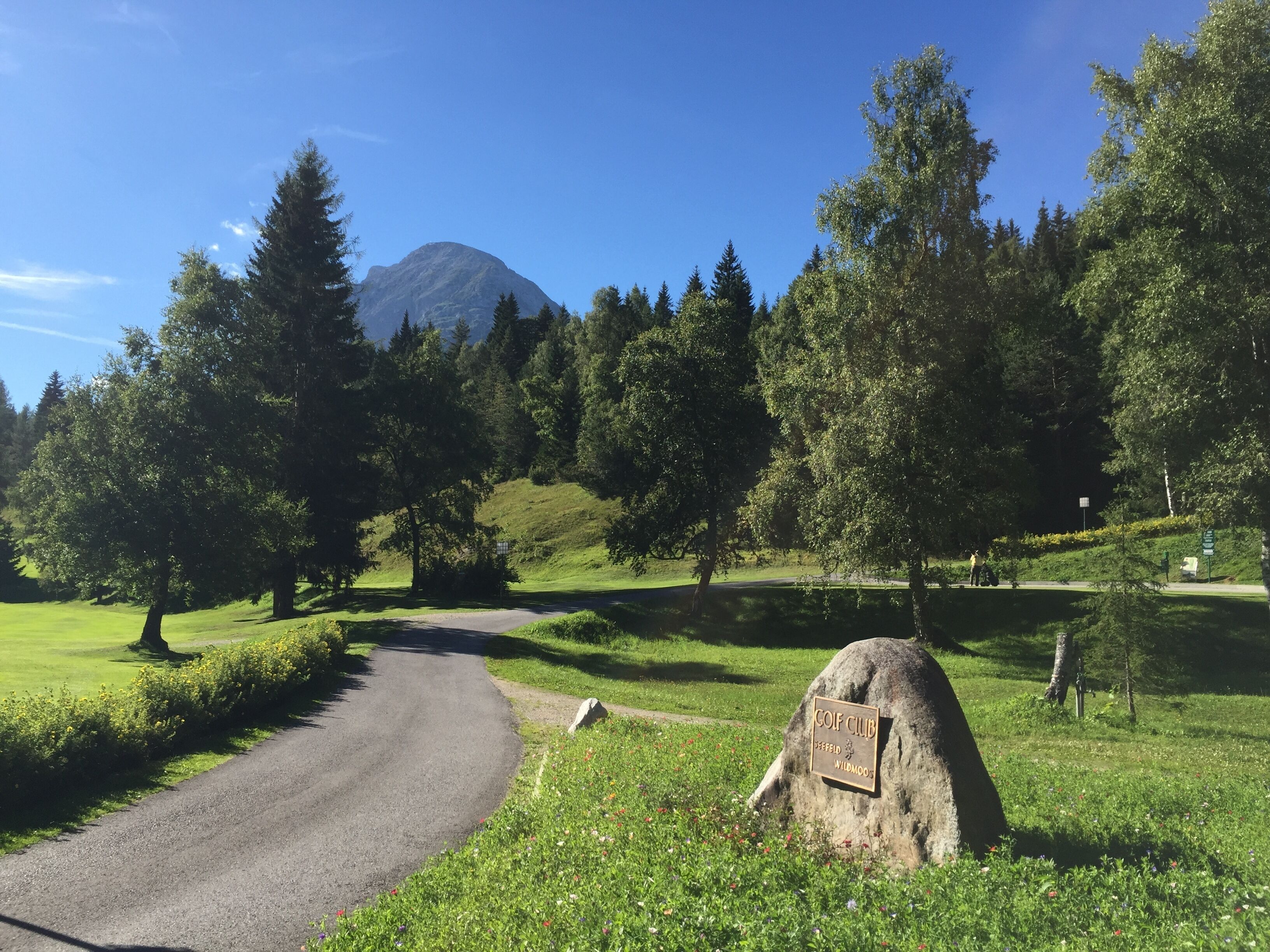 A golf course with a sign reading "Golf Club Seefeld Wildmoos."