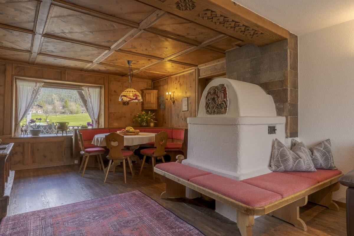 Un interior acogedor de cabaña con un banco de madera, una mesa de comedor y sillas.