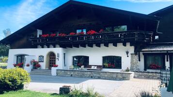 Traditional Alpine-style building with a charming balcony and garden area.