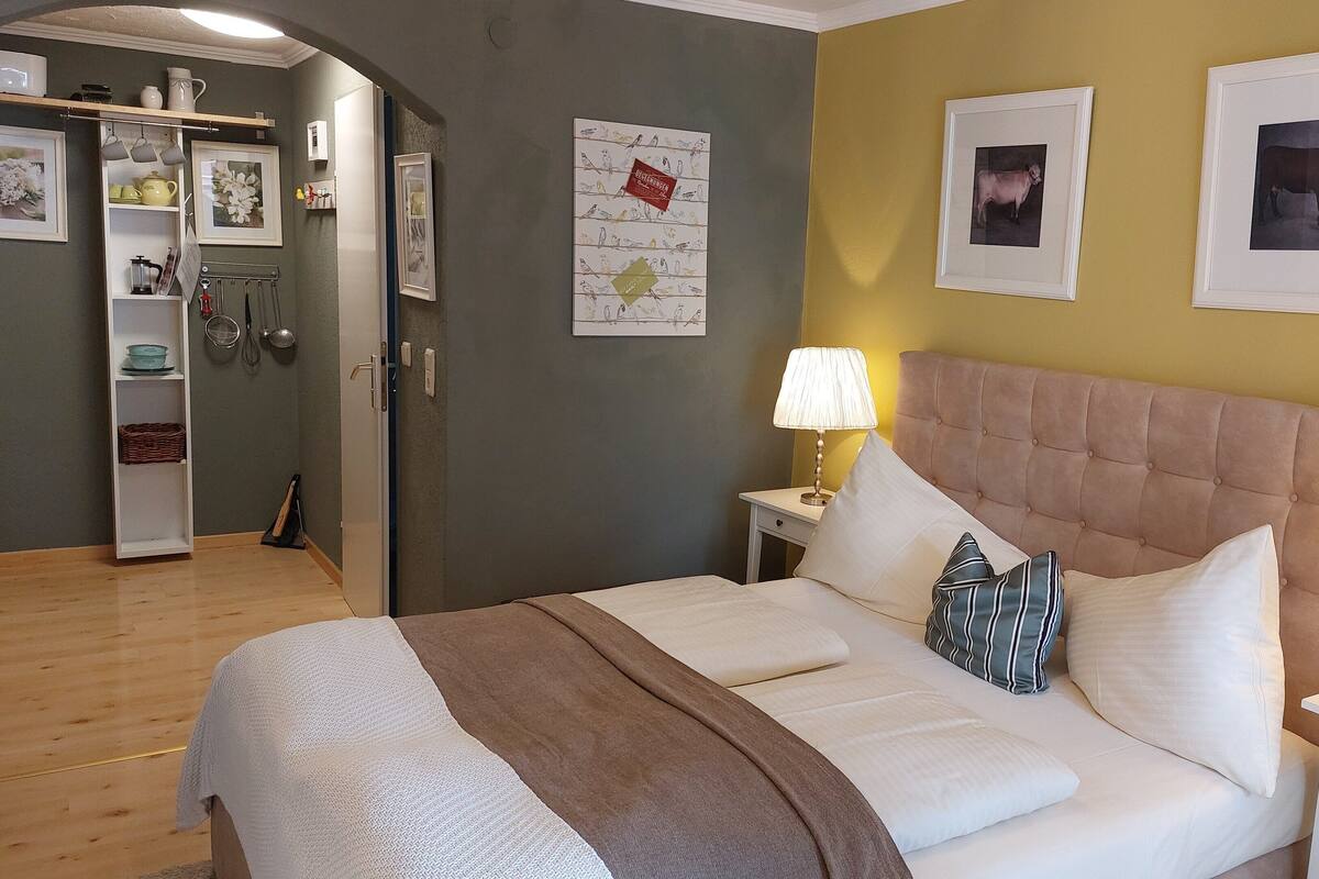 A neatly arranged bedroom with a bed, bedside tables, and a nightstand.