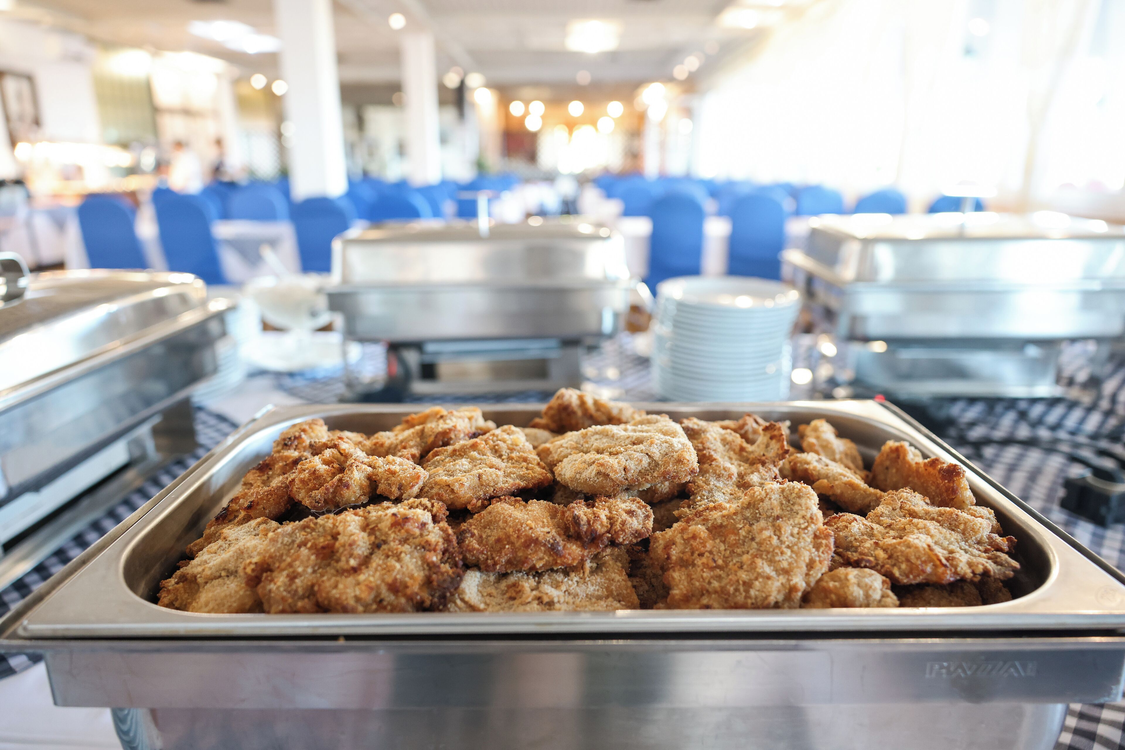 A buffet with a variety of dishes, including breaded chicken and other food items.