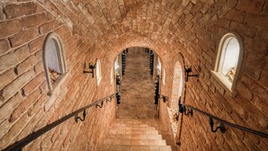 Eine Ziegelstein-Treppe mit Gewölbedecke, die zu einer höheren Ebene führt.