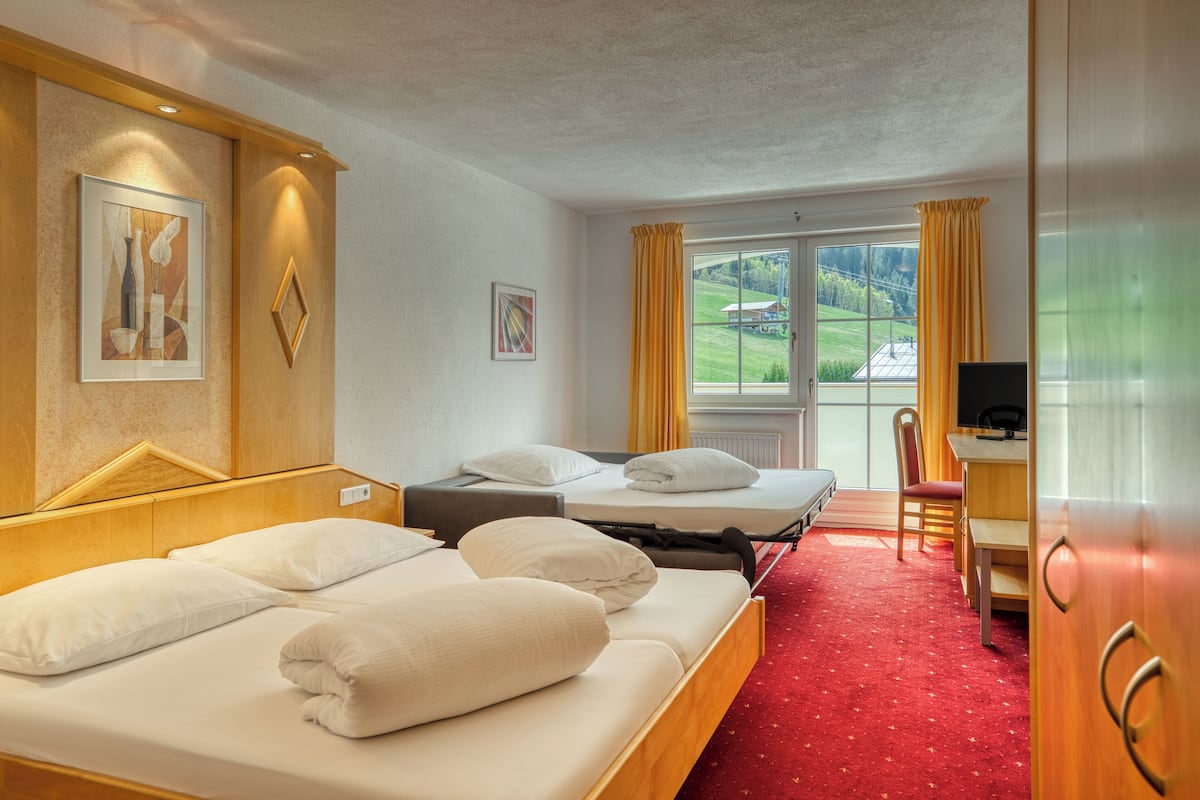 Hotellihuone, jossa on kaksi sänkyä, työpöytä ja tuoli.