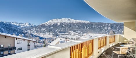 Een balkon met uitzicht op besneeuwde bergen.
