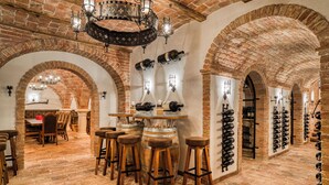 Eine Bar mit Backsteinwänden, Holzstühlen und Weinregalen.
