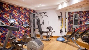 A gym with cardio machines, weightlifting equipment, and a mirror wall. - Valluga (Sankt Anton am Arlberg)
