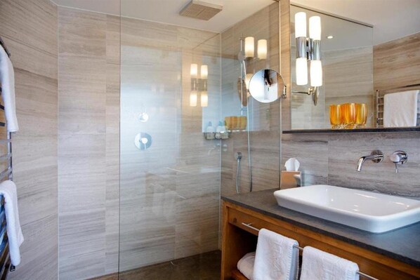 A modern bathroom with a glass-enclosed shower, a large mirror, and a white sink. - Valluga (Sankt Anton am Arlberg)