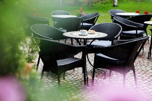 Outdoor wicker furniture with round tables, arranged on a paved patio. - Valluga (Sankt Anton am Arlberg)