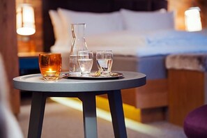 A round table with a candle, a glass of water, and a glass of wine in a hotel room. - Valluga (Sankt Anton am Arlberg)