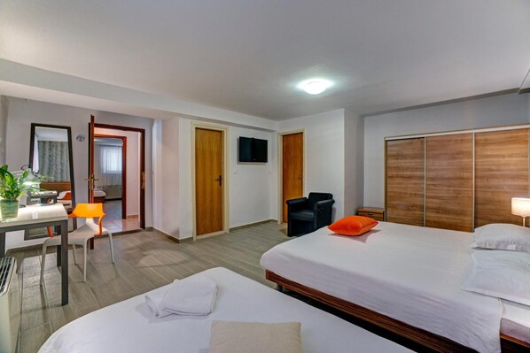 A hotel room with two beds, a desk with a chair, a TV, and a wardrobe. - Hotel Skradinski Buk (Skradin)