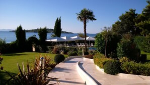 A resort with a pool, lounge chairs, and a view of the sea. - Hotel Villa Radin (Vodice)