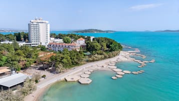 Di pantai, kursi berjemur, payung pantai, dan handuk pantai