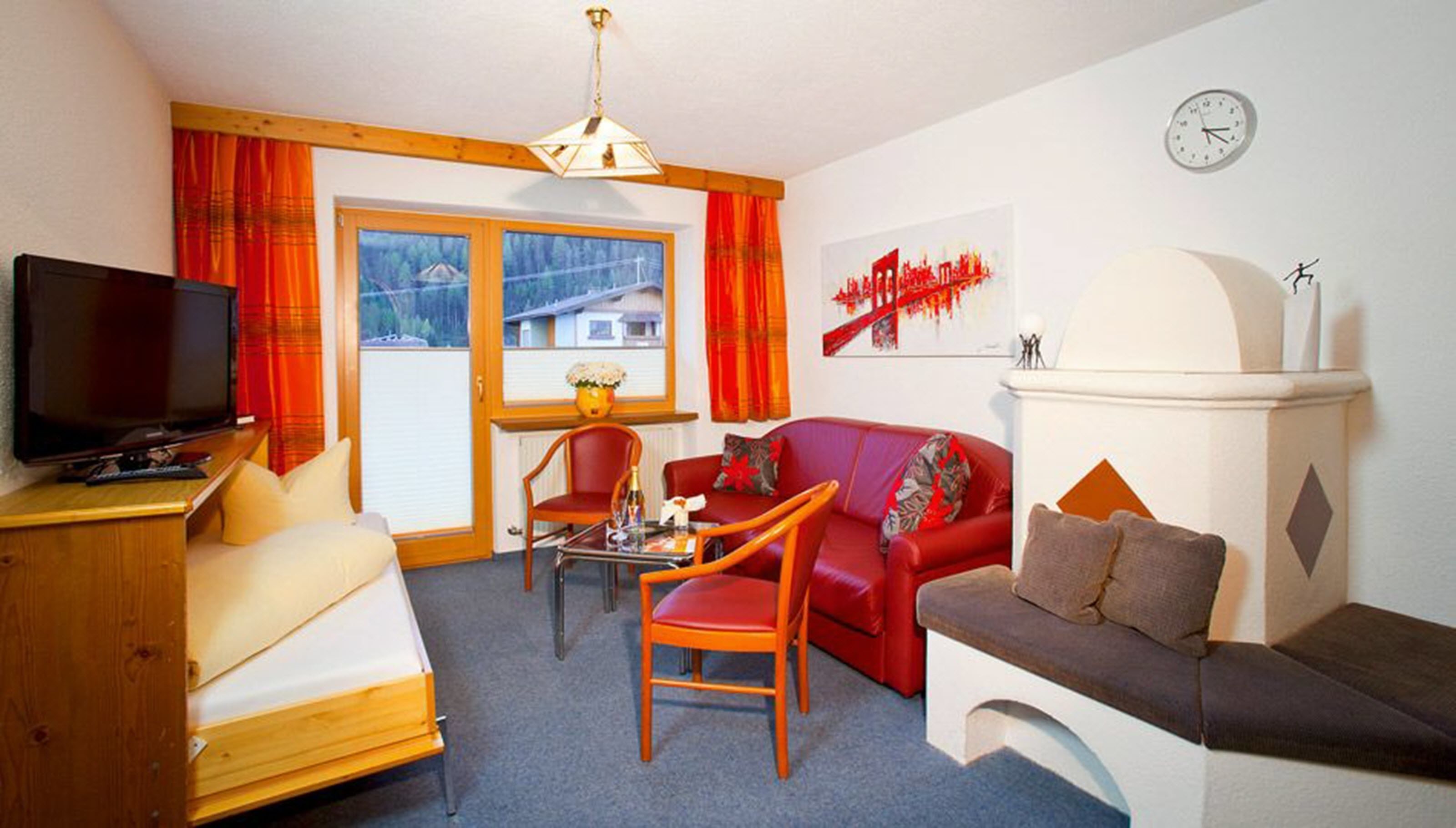A living room with a TV, red sofa, wooden chair, and a fireplace.