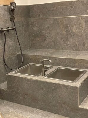 A bathroom with a shower area, a sink, and a toilet. - Aparthotel Garni Monte (Kartitsch)