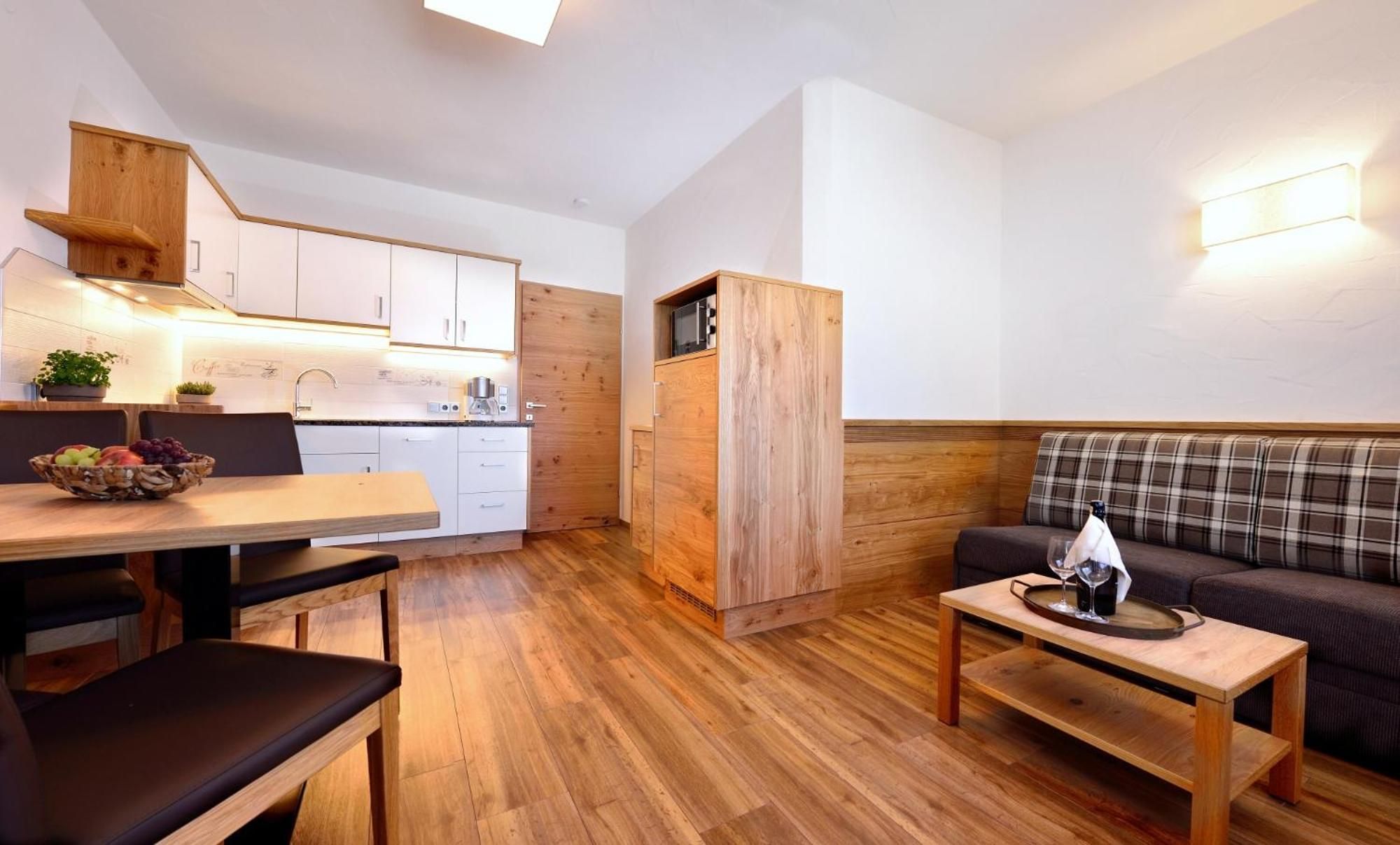 Un espacio habitable compacto con kitchenette, comedor y zona de estar.