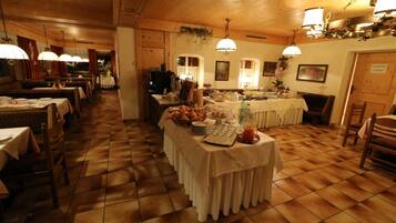 Ein Restaurant mit mehreren Tischen, einem Buffet und einem Holzboden.