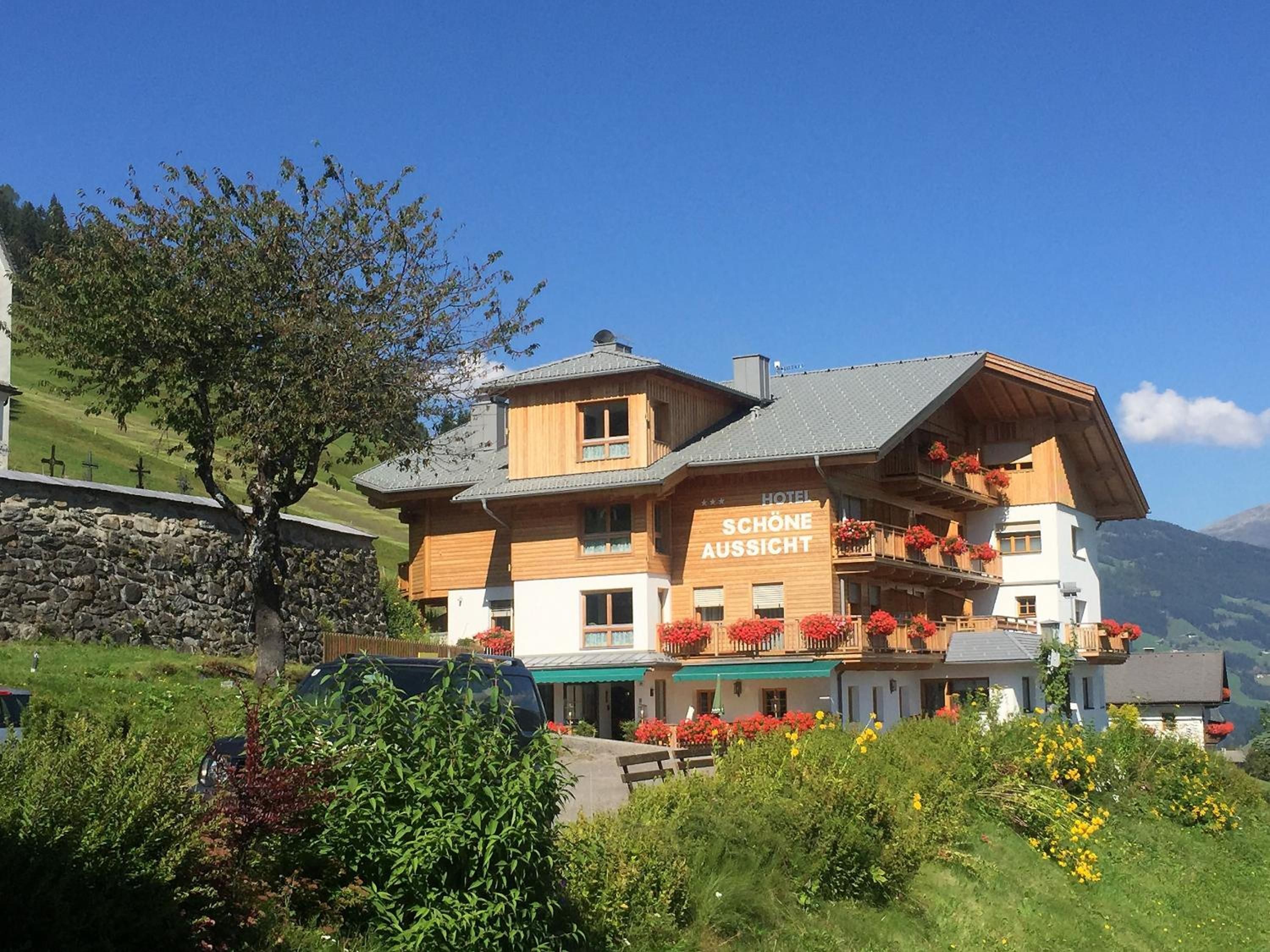 Un hotel con un letrero que dice 'Schöne Aussicht' en una zona montañosa.