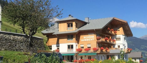 Un hotel con un letrero que dice 'Schöne Aussicht' en una zona montañosa.