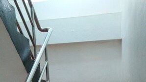 Un escalier avec des rampes en métal et des marches rouges.