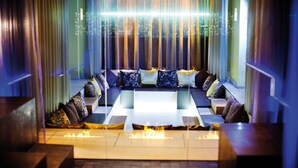 A modern lounge area with a sofa set, a coffee table, and a fire feature. - Hotel Schwarzbrunn Superior (Stans)