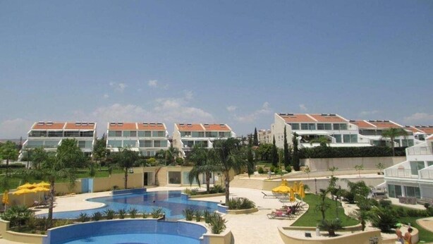 A resort with multiple buildings, a large swimming pool, and outdoor seating areas. - Bayview Gardens (Limassol)