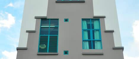 A multi-story building with a symmetrical facade, featuring a central entrance and evenly spaced windows.