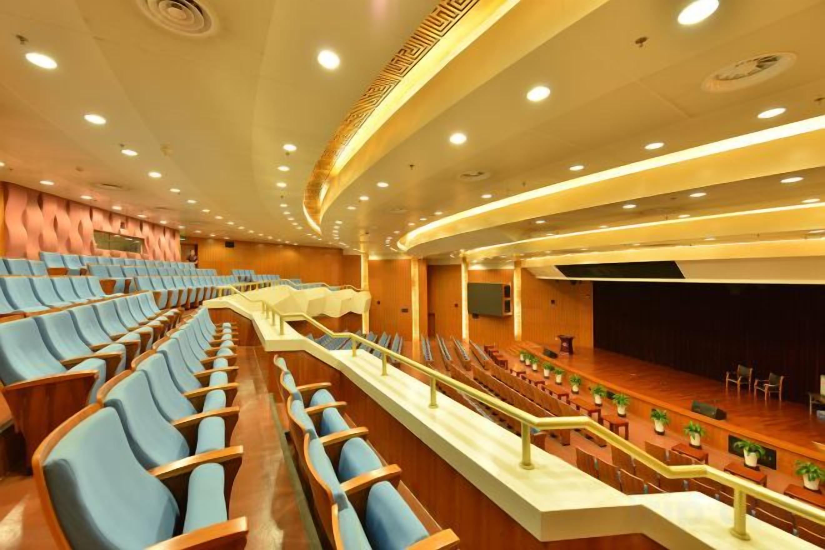 Een grote aula met trappen, een podium en een centrale gang.