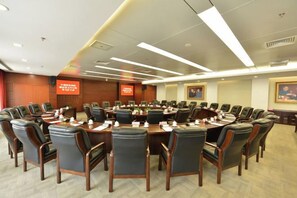 A conference room with a large oval table surrounded by chairs, equipped with nameplates and water bottles. - China Hall of Science and Technology (Beijing)