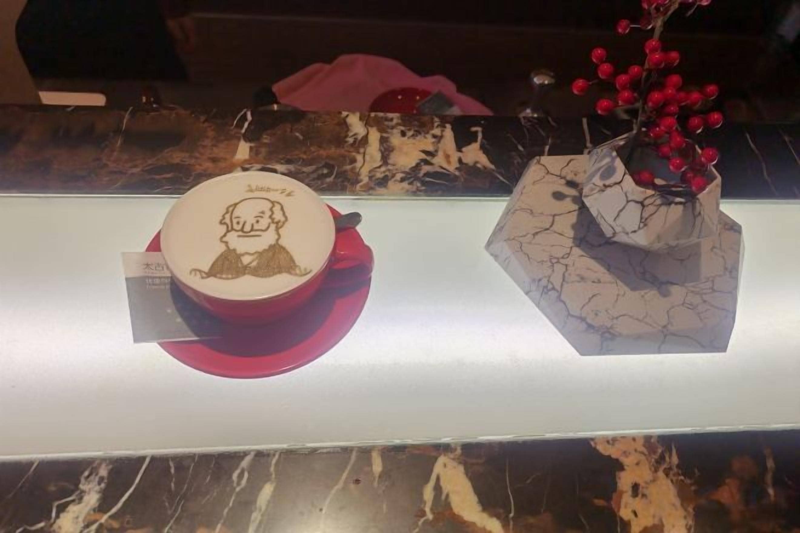Una vitrina con un cuenco de cerámica y un jarrón con bayas rojas.