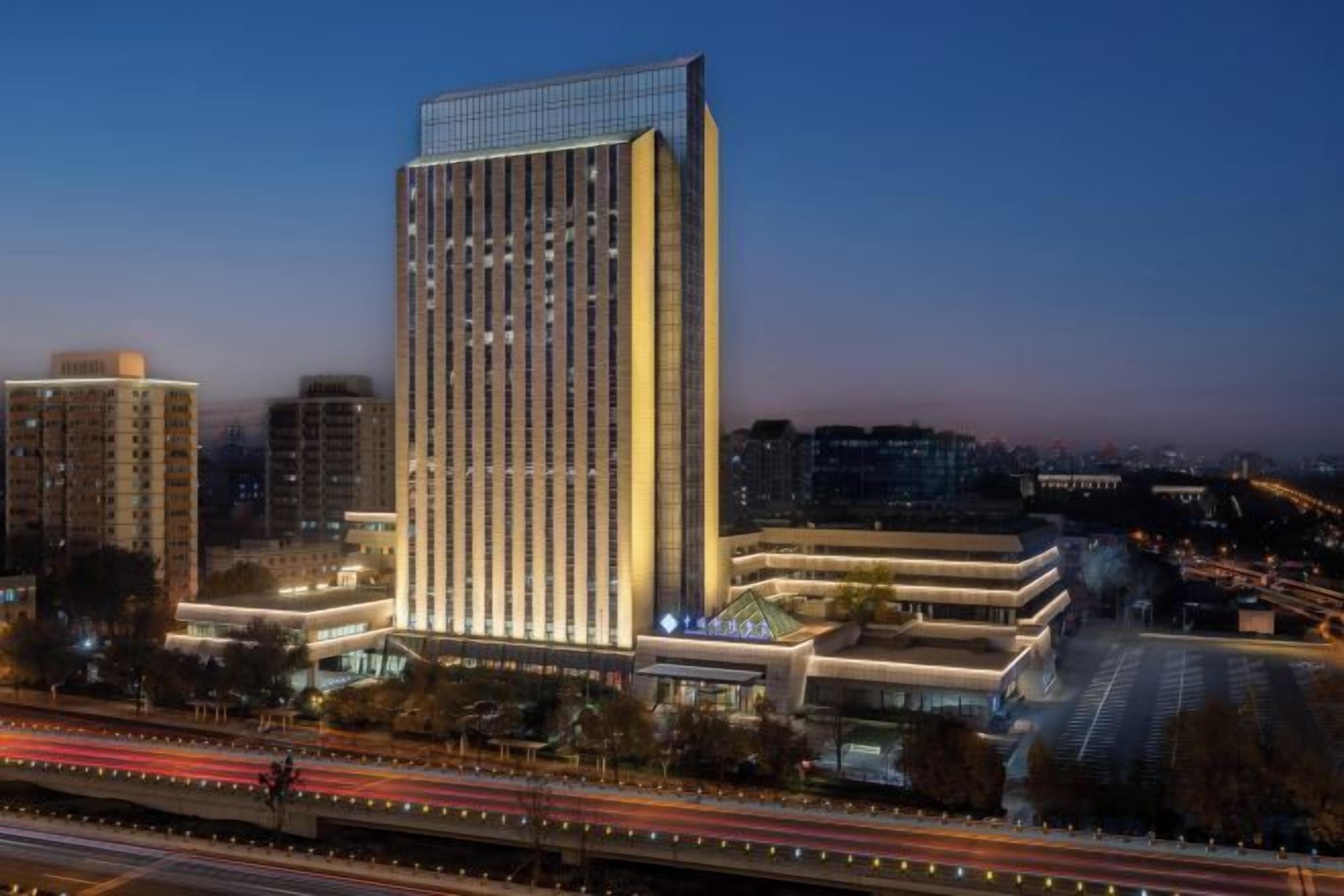 A high-rise hotel with a modern design, featuring a prominent vertical structure and a well-lit facade.
