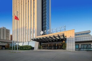 A modern building with a prominent vertical structure and a flat-roofed entrance. - China Hall of Science and Technology (Beijing)