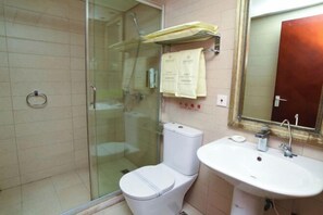 A bathroom with a glass-enclosed shower, a white toilet, and a sink with a mirror above it. - China Hall of Science and Technology (Beijing)