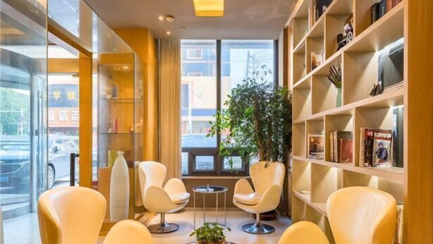 A modern lounge area with leather chairs, a small coffee table, and a bookshelf. - Jinjiang Inn (Huaibei Mengshan Road) (Huaibei)
