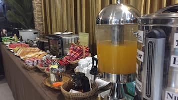 A buffet setup with various food items and a beverage dispenser.