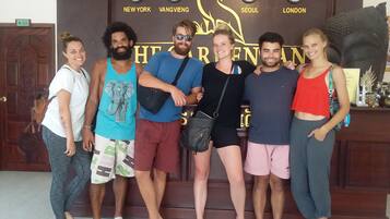 A group of people standing in front of a wall with clocks and city names.