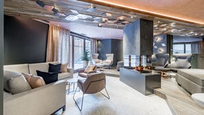 A modern living room with a fireplace, comfortable seating, and a unique ceiling design.