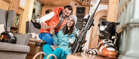 A cozy indoor setting with wooden furniture, skis, and a person in a wheelchair.