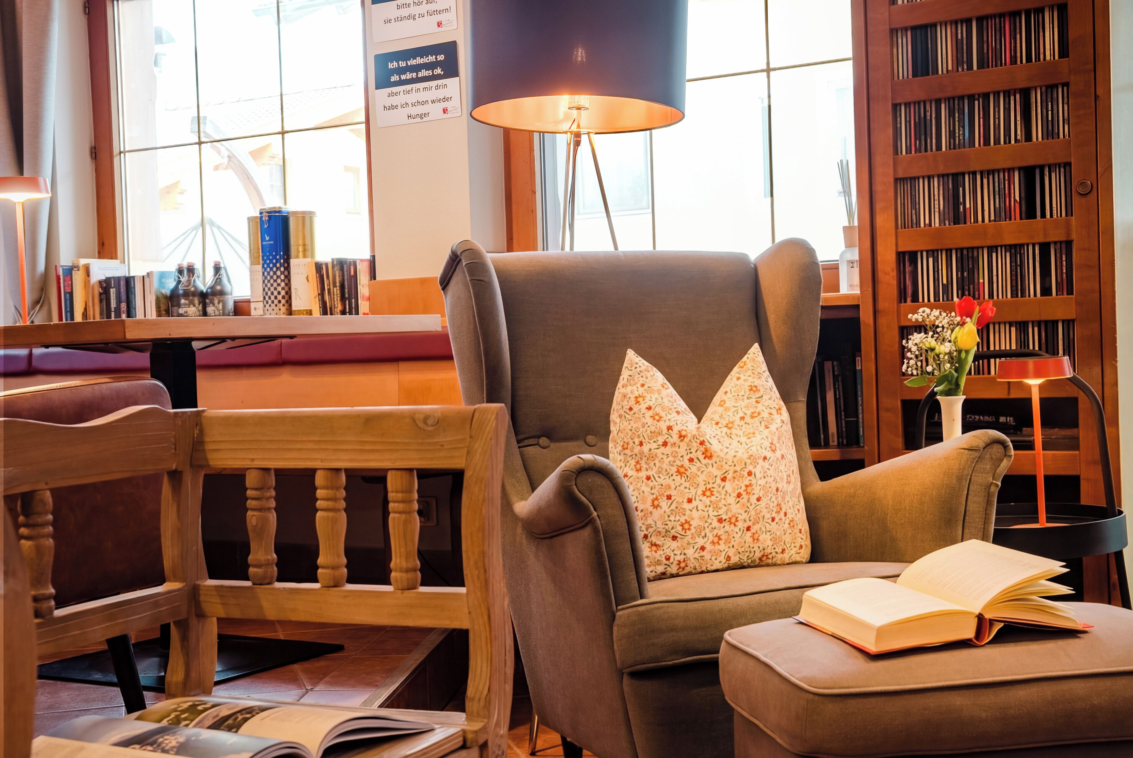 A cozy reading area with a chair, a table, and a bookshelf.