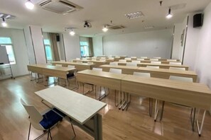 A conference room with multiple tables and chairs, a whiteboard, and a projector. - HanTing Hotel (Chongqing Jiazhou Huahuiyuan Subway Station) (Chongqing)