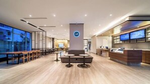 A modern hotel lobby with a reception desk, seating area, and large windows offering a view of the cityscape. - HanTing Hotel (Chongqing Jiazhou Huahuiyuan Subway Station) (Chongqing)
