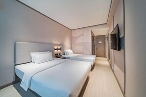 A modern hotel room with two beds, a TV mounted on the wall, and a hallway leading to another room. - HanTing Hotel (Chongqing Jiazhou Huahuiyuan Subway Station) (Chongqing)