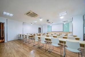 A conference room with rows of white chairs, a projector screen, and a whiteboard. - HanTing Hotel (Chongqing Jiazhou Huahuiyuan Subway Station) (Chongqing)