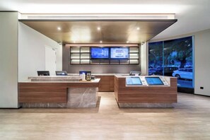 A reception area with a modern design, featuring a reception desk, a digital display, and a large window with a view of the outside. - HanTing Hotel (Chongqing Jiazhou Huahuiyuan Subway Station) (Chongqing)