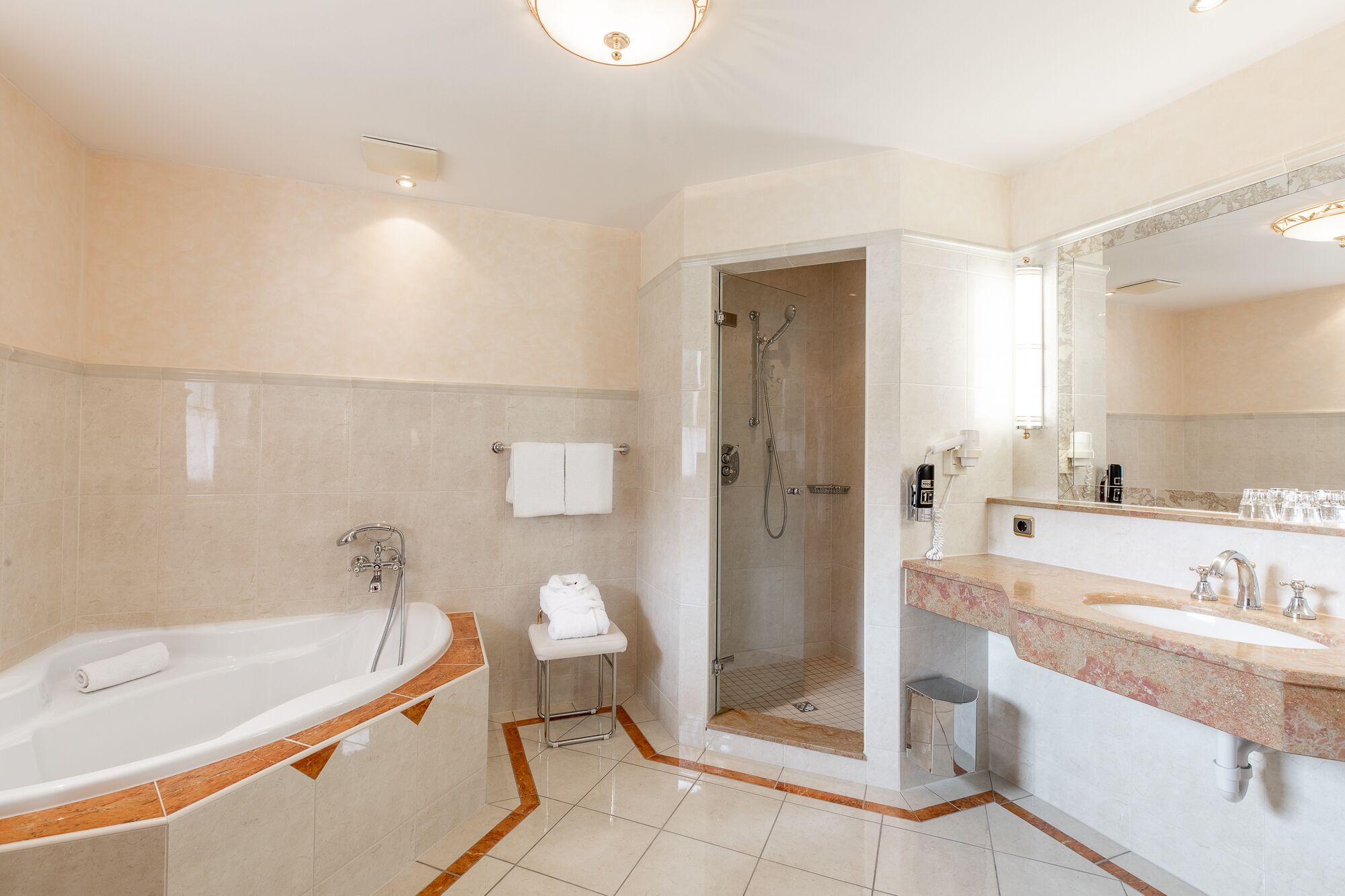 A modern bathroom with a bathtub, shower, and vanity.